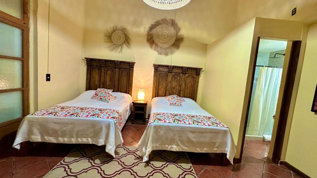 a bedroom with two beds and a mirror at Casona Bartolome in Morelia