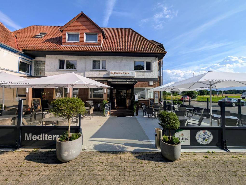 un restaurant avec des tables et des parasols en face d'un bâtiment dans l'établissement Hotel & Restaurant Mediterrane Küche, à Horn-Bad Meinberg