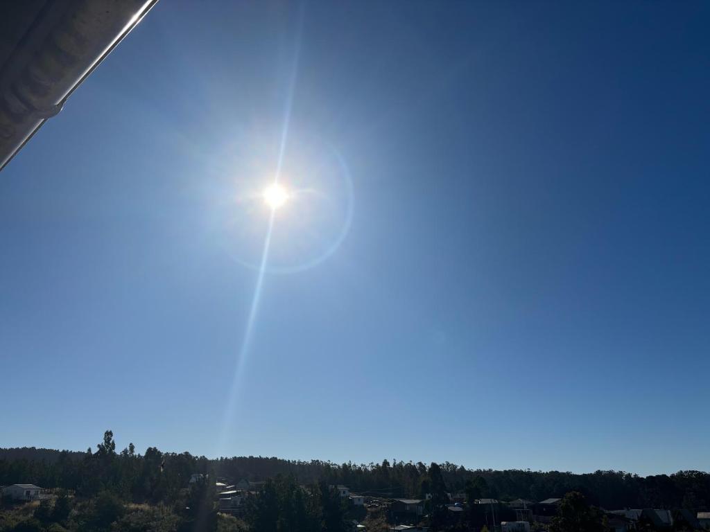 een zon schijnt in de lucht boven een stad bij Cabañas Vitalis in Curanipe