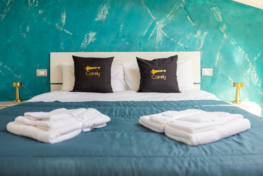 a bed with white towels on a blue bed at Cairoly Residence in Termoli