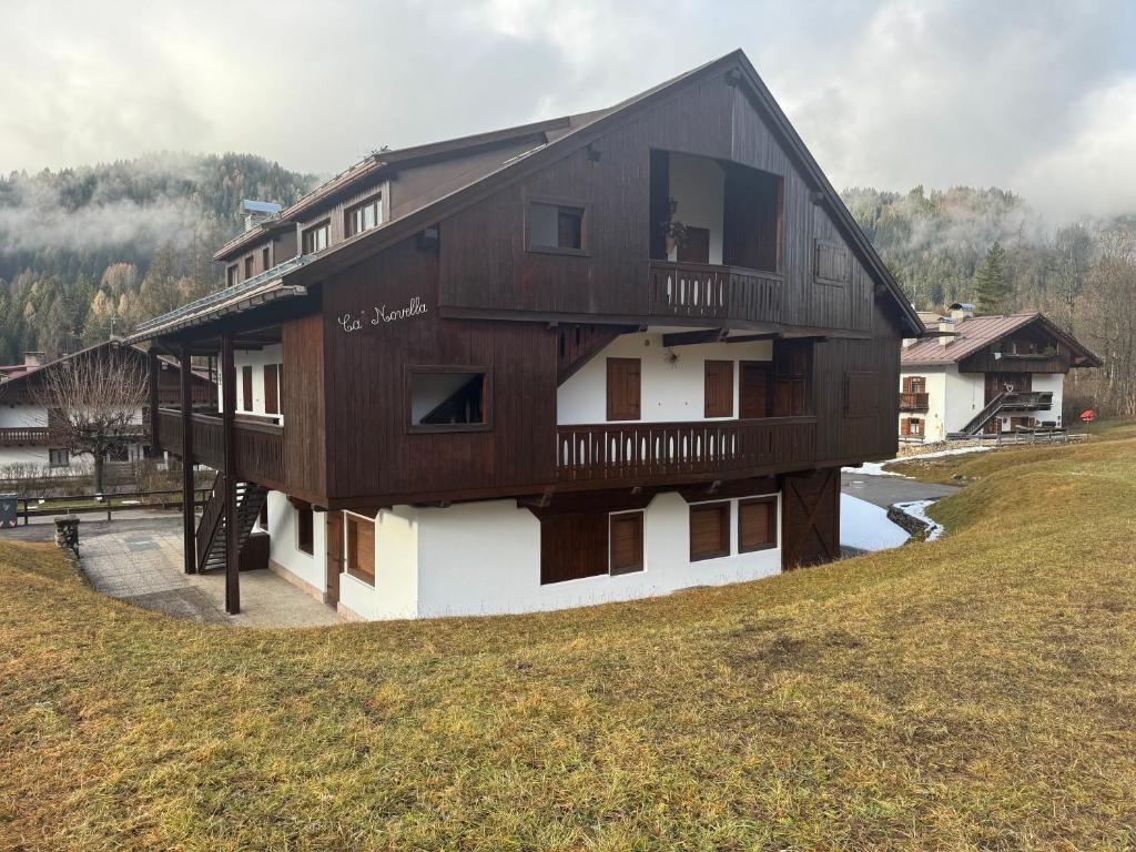 een groot houten huis bovenop een heuvel bij Ca Novella Apartment in San Vito di Cadore