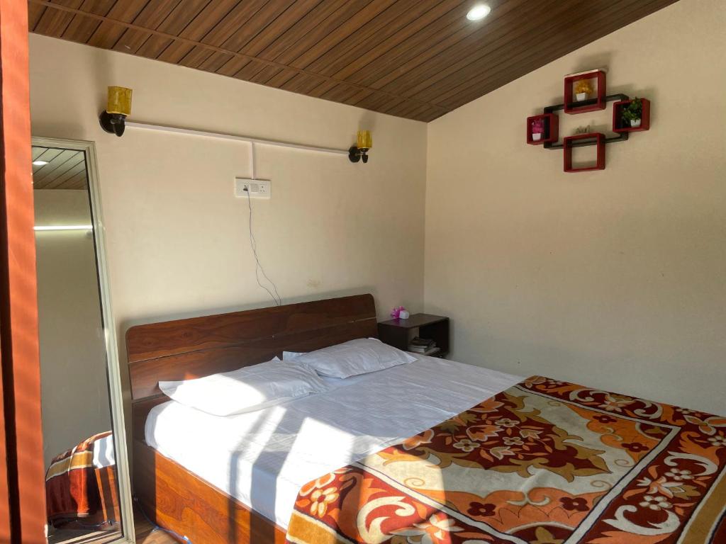 a bedroom with a bed with a wooden head board at Cloudscape Cottage in Shimla