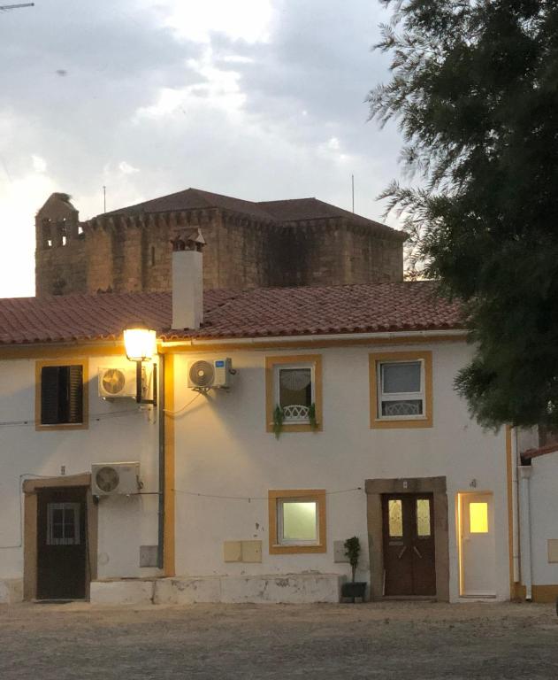 a white house with a castle in the background at Charming House Secret Rose in Flor da Rosa