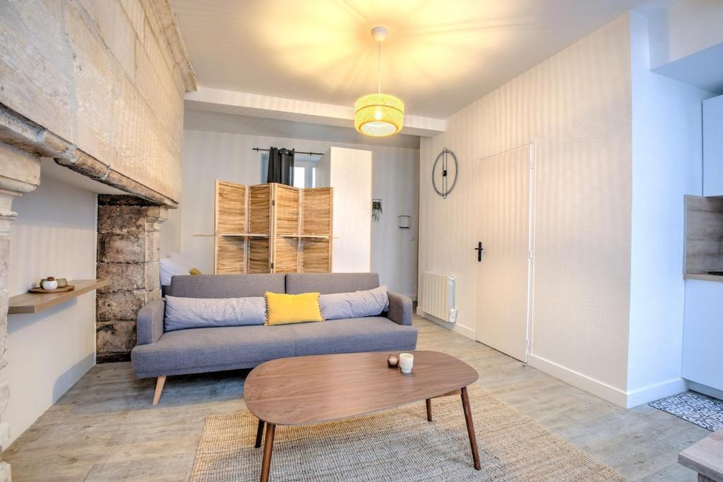 een woonkamer met een bank en een tafel bij Wisdom at heart in Périgueux