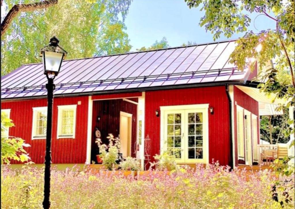 een rood huis met een vrouw die in de deuropening staat. bij Villa Tilda in Matildedal