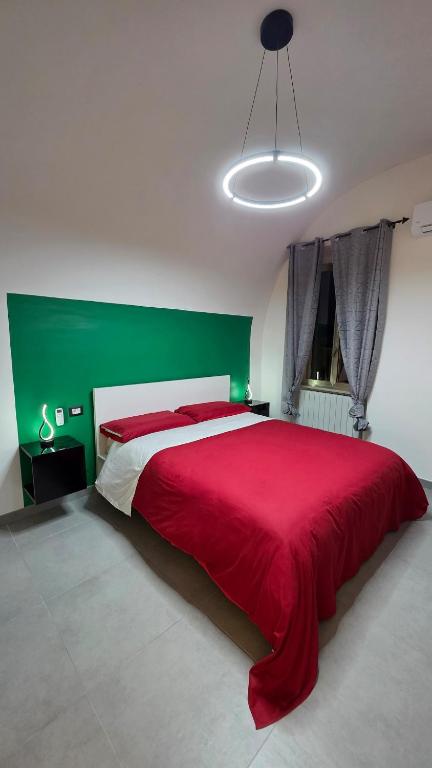 a bedroom with a red bed with a green wall at Agli Archi Eco House in Chieti