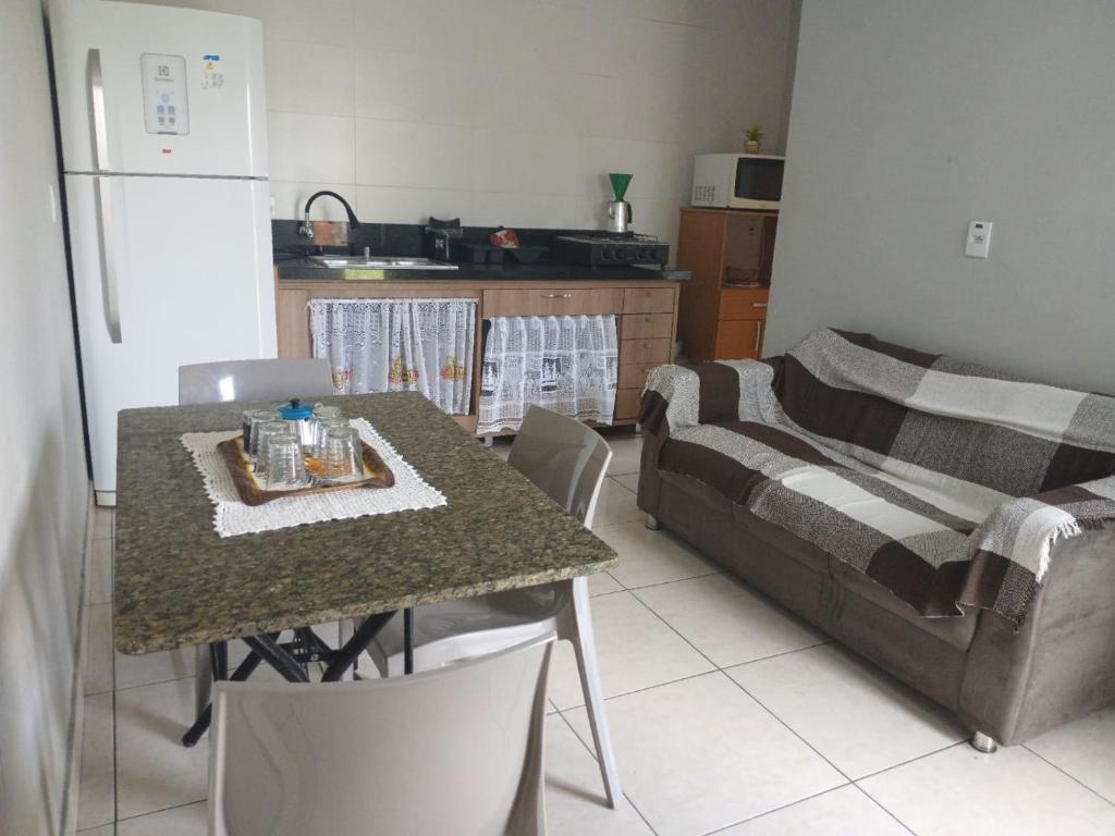 a kitchen with a table and a couch in a kitchen at Residencial Daitx in Capão da Canoa