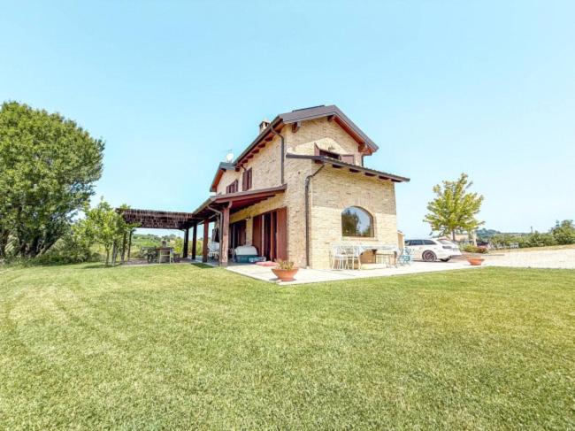 a large house with a grass field in front of it at un MONDO A PARTE in Monsampolo del Tronto