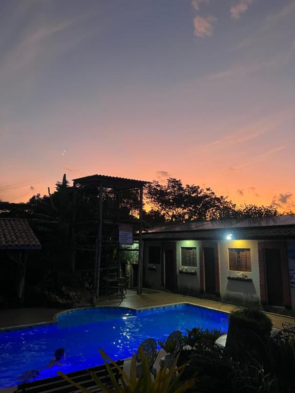a swimming pool in front of a house with a sunset at Pousada em Itupeva in Itupeva