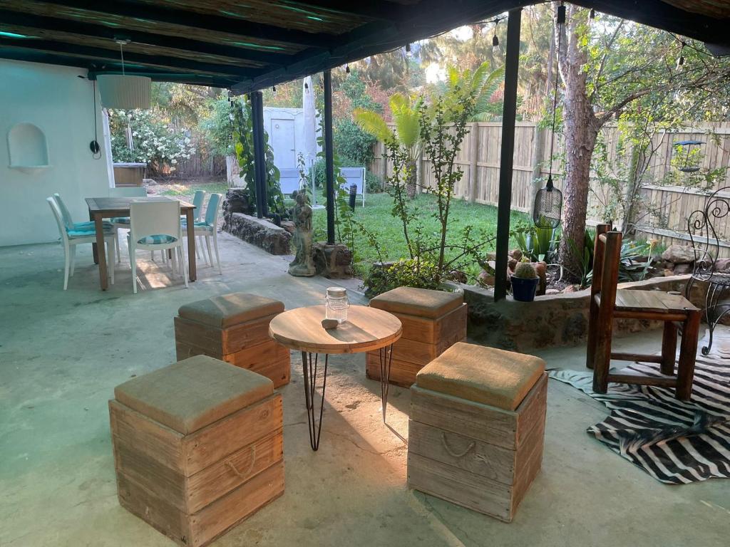 un patio avec une table et des tabourets et une table et des chaises dans l'établissement Villa Olivia, à Riebeek-Kasteel