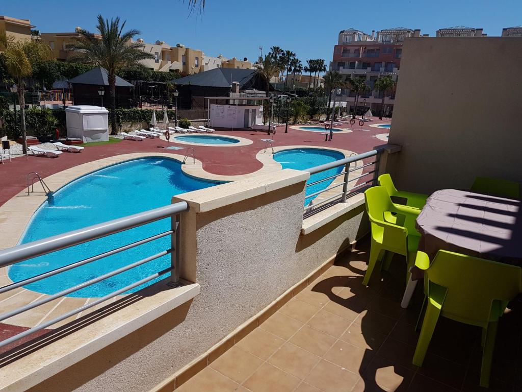 einen Balkon mit einem Pool sowie Tischen und Stühlen in der Unterkunft Apartment in Marina Rey Complex in Vera