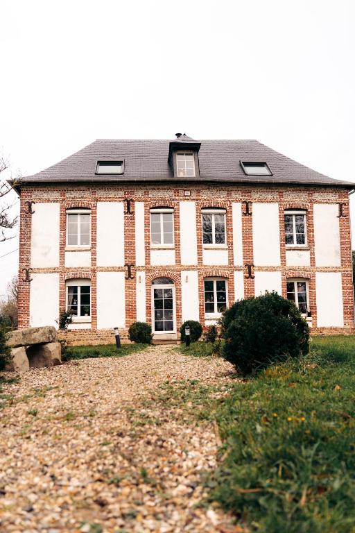 a large brick house with a yard in front of it at Maison Le Catelier in Le Catelier