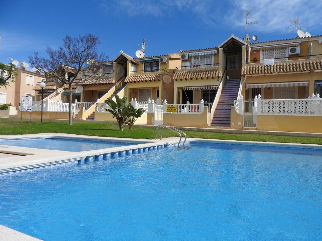 a swimming pool in front of a house at Bungalow Lomas Del Golf in San Miguel de Salinas