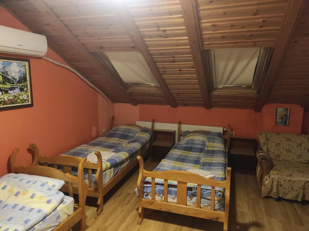 a room with two beds and a couch and a chair at Motel Lovac in Štrpce