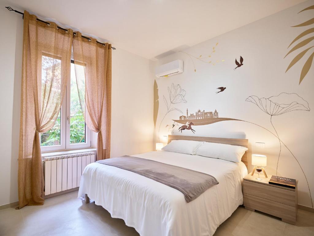 a bedroom with a large white bed and a window at Domus Pallium in Siena