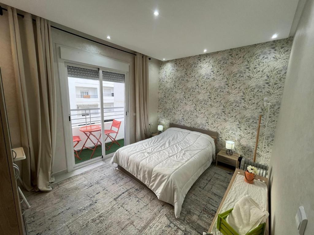 une chambre avec un lit et un balcon avec une table dans l'établissement Charming, Peaceful Apartment, Sea, à Tanger