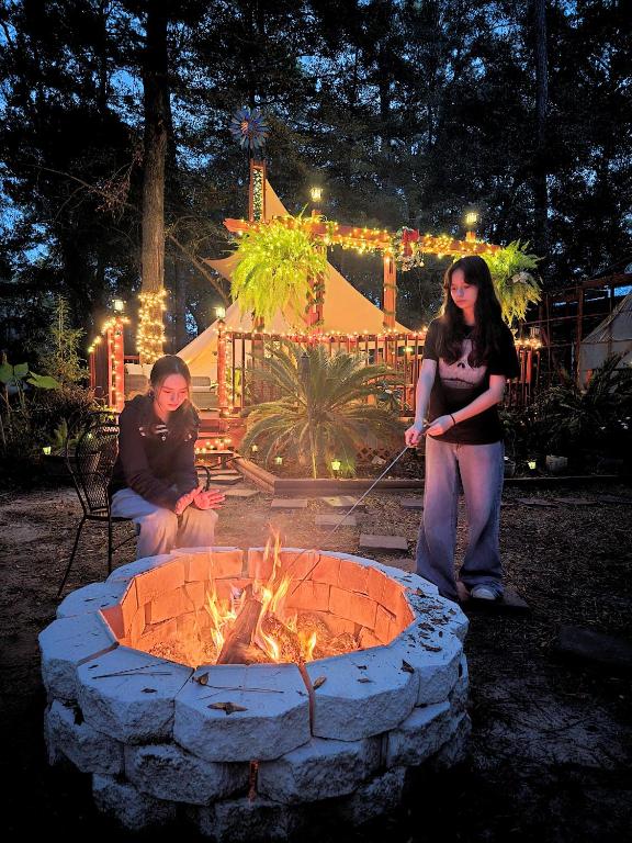a group of people standing around a fire pit at Paradise Gardens Glamping in Westville