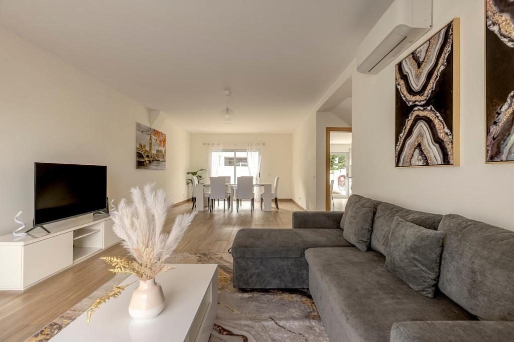 un salon avec un canapé et une télévision dans l'établissement Bright & Airy 3BR Spacious Villa, à Sesimbra