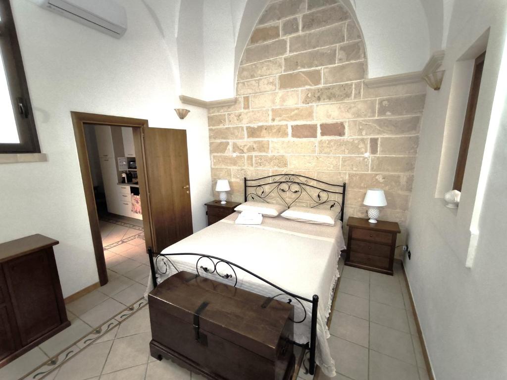 a bedroom with a bed and a stone wall at Casa Naida in Nardò