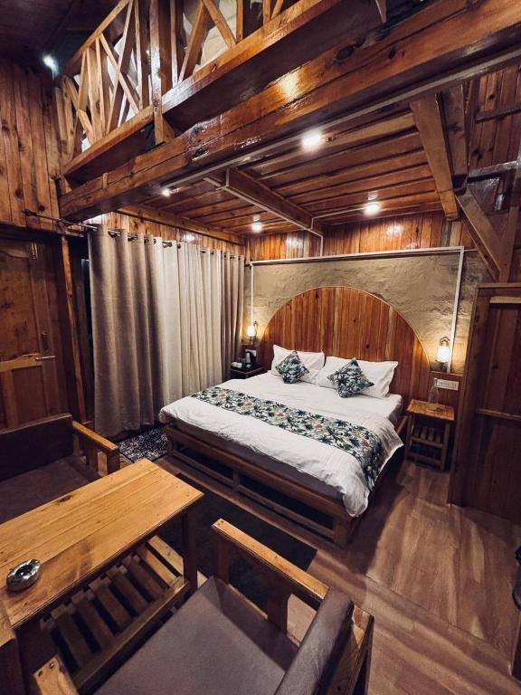 a bedroom with a large bed and a wooden ceiling at Mountain Nest Stay in Jibhi