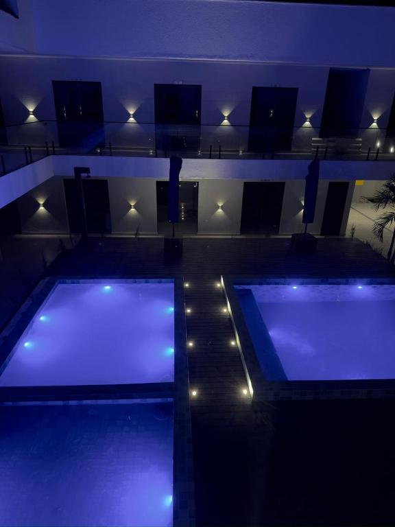 een zwembad 's nachts met blauwe lichten bij Studio Vila Eco Barra in Barra Grande