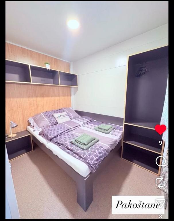 una piccola camera da letto con un letto con un piumone viola di Laura, Milan a Pakoštane