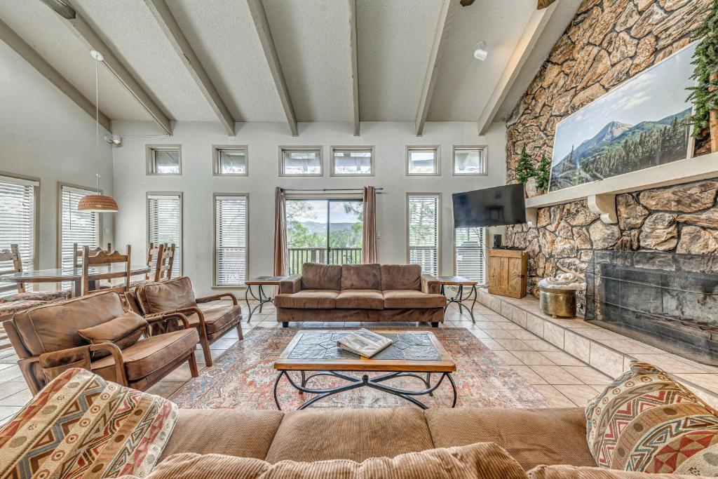 un soggiorno con divani e un muro in pietra di Ruidoso Home with Private Wet Bar and Pool Table a Ruidoso