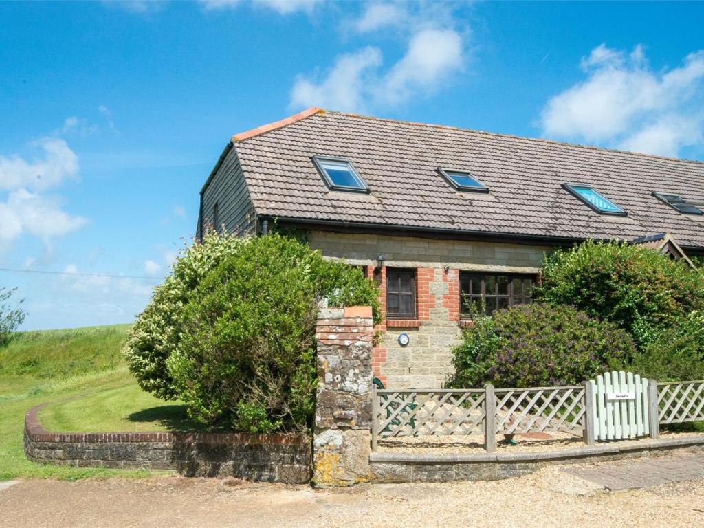 an old brick house with a fence in front of it at 2 Bed in Godshill oc-ic072 in Godshill