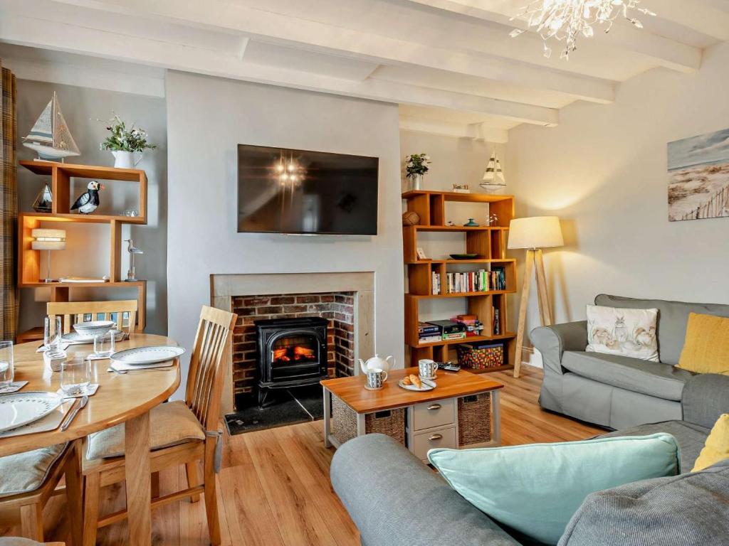 a living room with a table and a fireplace at 2 Bed in Seahouses oc-cn082 in Seahouses