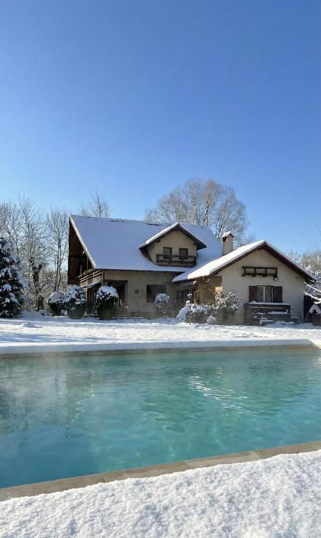 a house in the snow with a pool of water at Casa Csiki in Râşnov