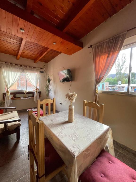 een eetkamer met een tafel, stoelen en ramen bij Departamento Ayllu IV in Tilcara