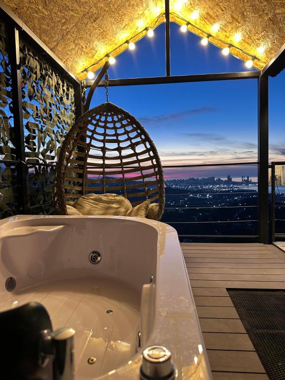 a bath tub on a balcony with a view of the city at Silent Hill მშვიდი გორა in Batumi