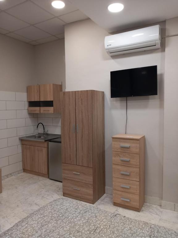 una cucina con armadi in legno e una TV a schermo piatto di Litsa Fit a Salonicco