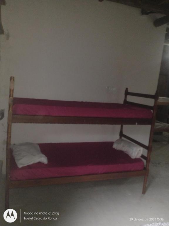 een stapelbed in een kamer met roze lakens bij Hostel Cedro do Ronca in Paraty