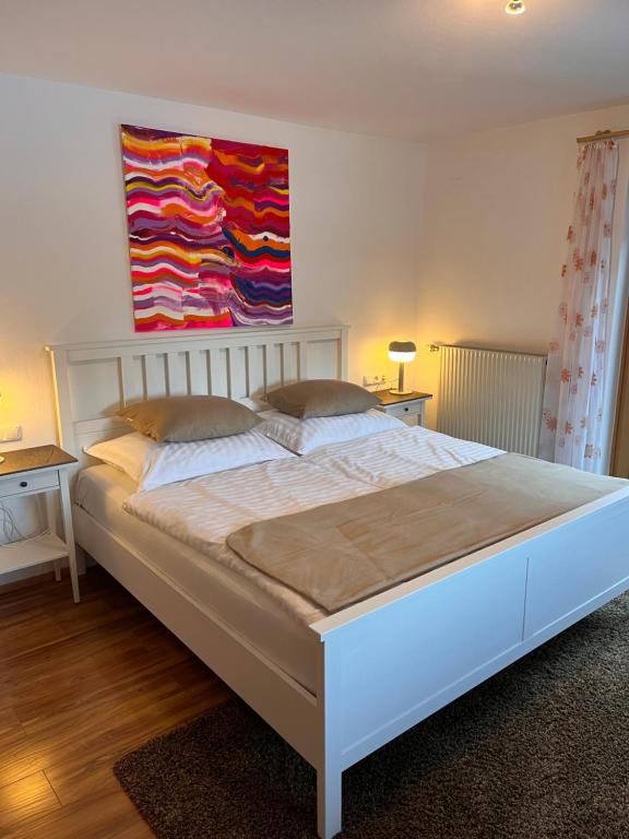 a bed in a bedroom with a painting on the wall at Bergkraft in Assling