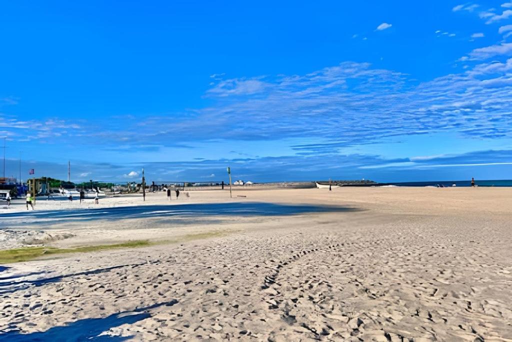 a beach with people walking on the sand at Quarto em Matinhos | Viva o Melhor do Litoral in Matinhos