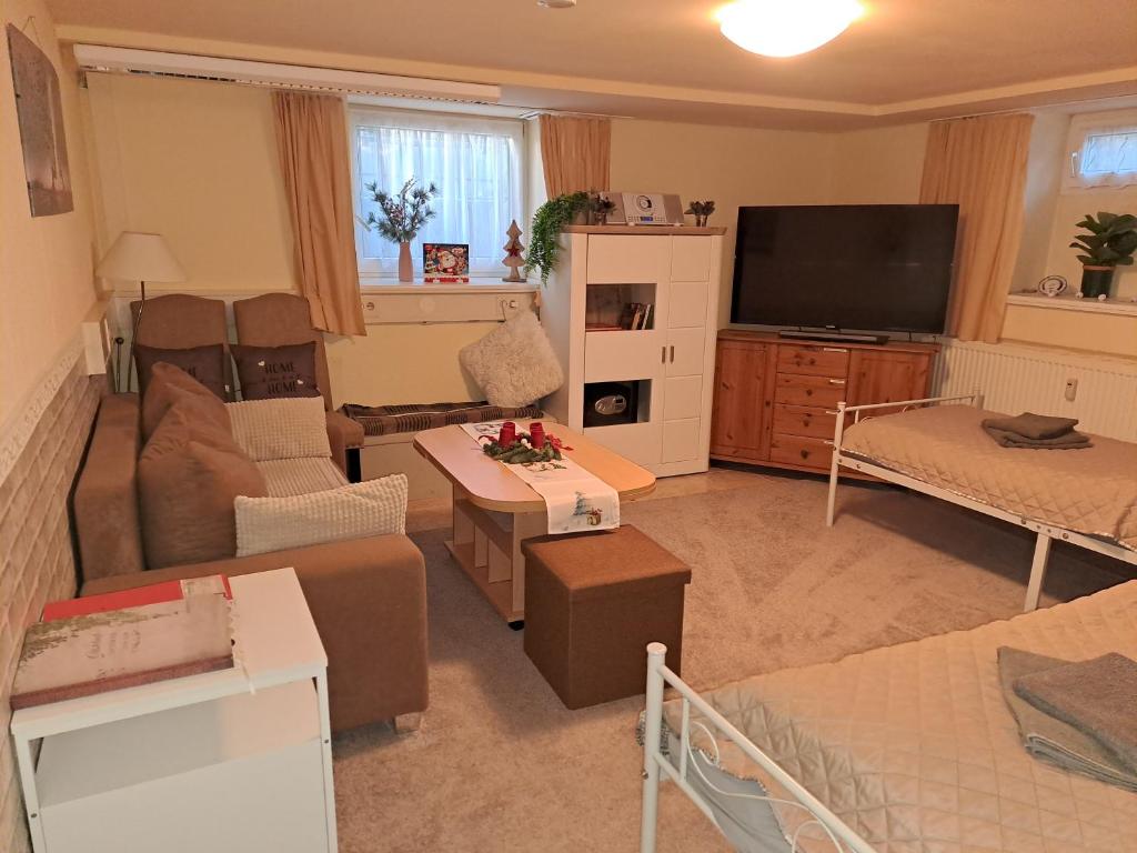 een woonkamer met een bank en een tv bij Unterkunft Mohr - Gemütlichkeit im Souterrain in Schmerwitz