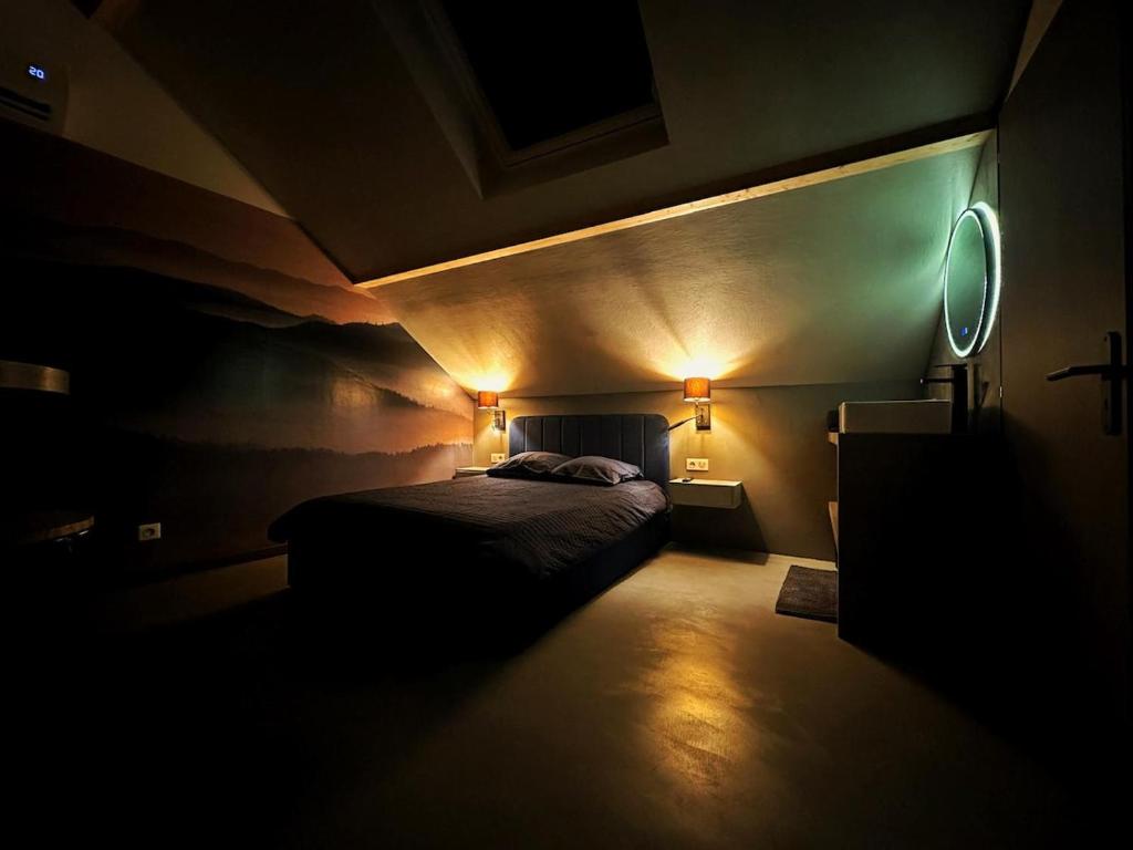 a dark room with a bed and two lights at L'annexe 3 - Cosy studio Dole in Foucherans