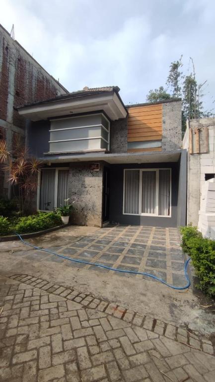 a house with a blue hose in front of it at Aby's Guest House in Tlekung