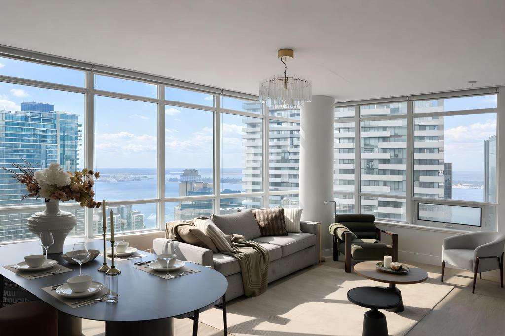 ein Wohnzimmer mit Sofa und Tisch in der Unterkunft 40th Fl Designer Lakeview 2BR PATH & Union Access in Toronto