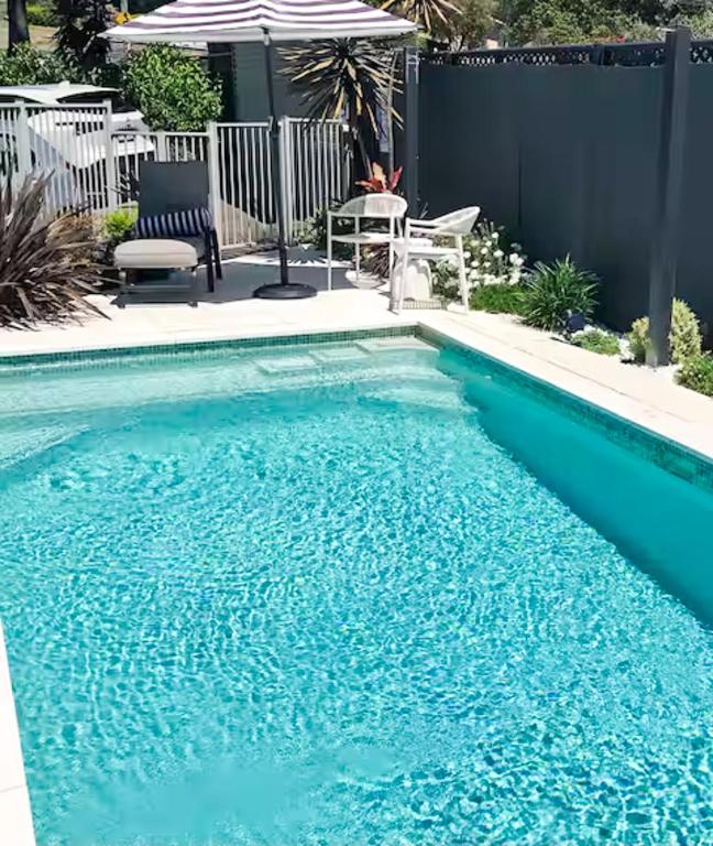 a swimming pool with blue water in a backyard at Pool Heated Lake Views 1BR Apartment in Coal Point