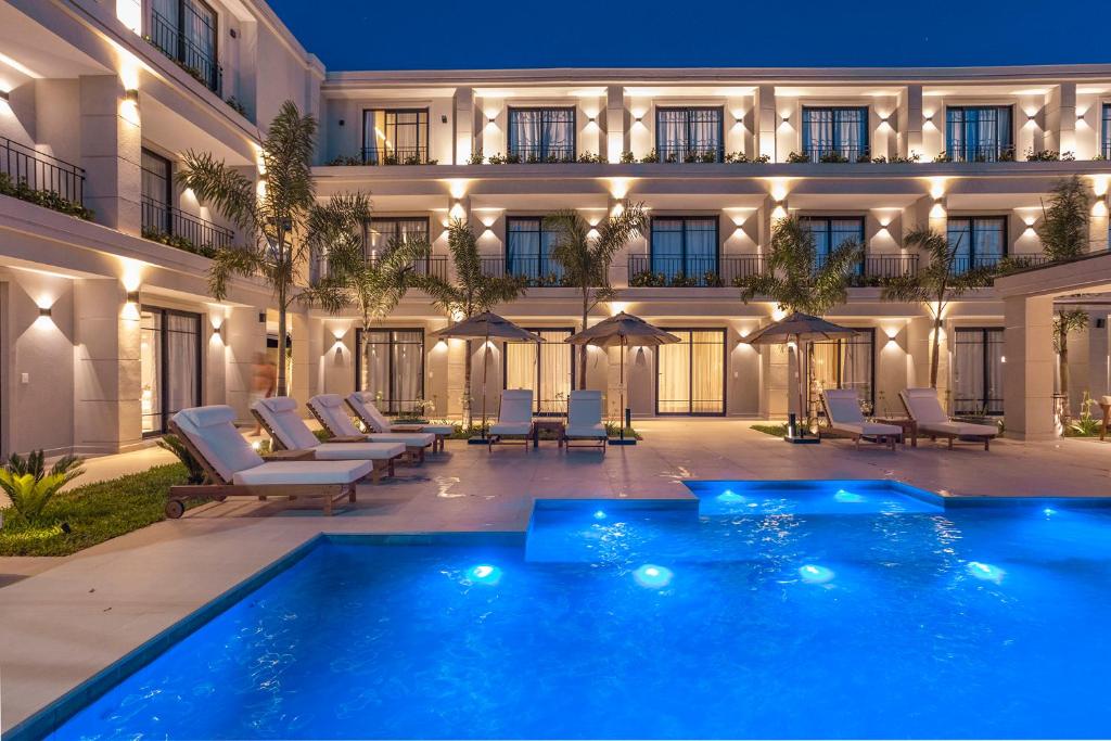 a hotel with a swimming pool in front of a building at Solena in Camburi