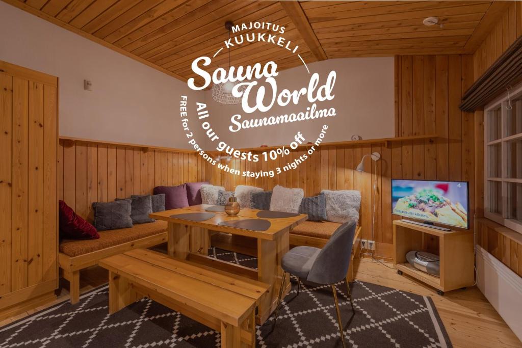 un soggiorno con un tavolo e un cartello con la scritta sauna world summersmite di Kuukkeli Apartments Tokka a Saariselka