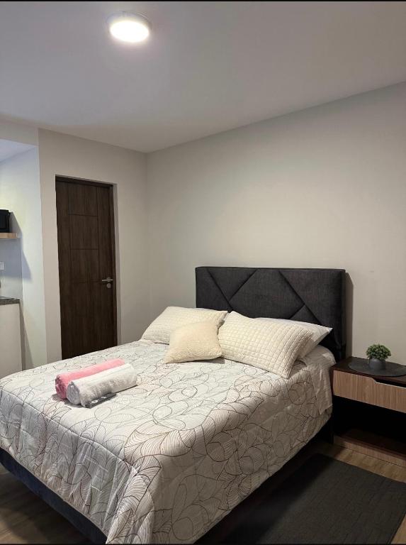 a bedroom with a large bed with a black headboard at Suite Prado-PC0n Garant1a in Cochabamba