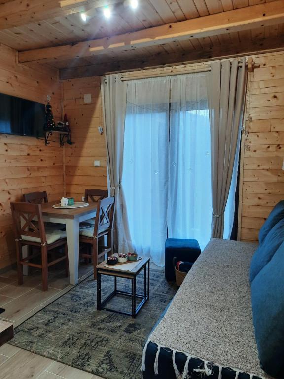 een slaapkamer met een bed en een tafel en stoelen bij Vikendica Neven 3 in Popovići