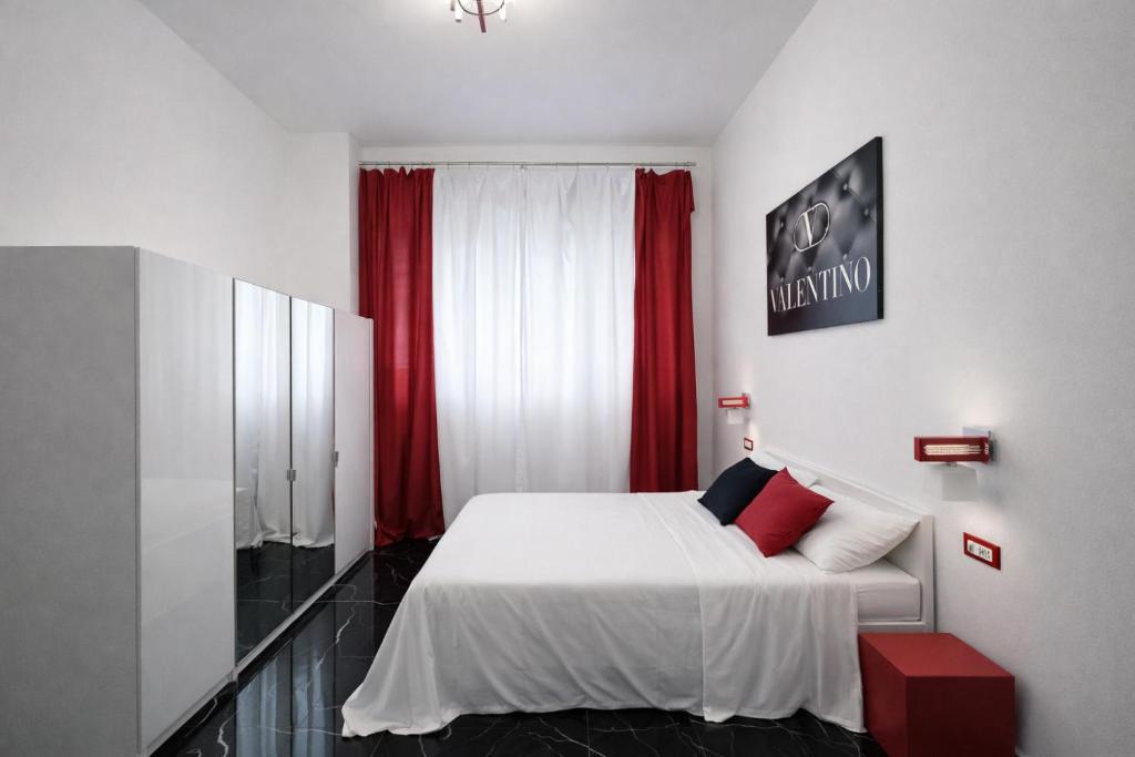 Schlafzimmer mit einem weißen Bett und roten Vorhängen in der Unterkunft Maison Valentino in Mailand
