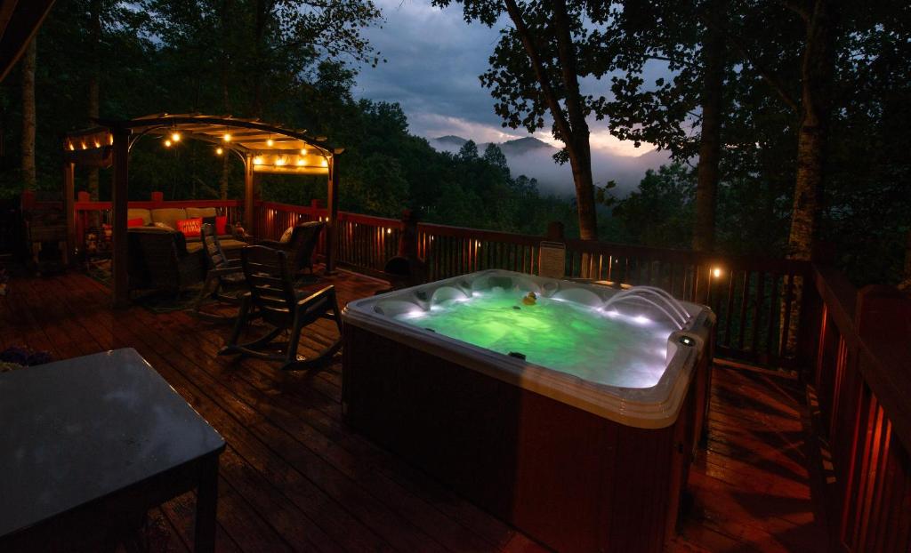 a hot tub sitting on a deck at night at Hot Tub, Fire Pit and Lake Access! Almond Cabin in Almond