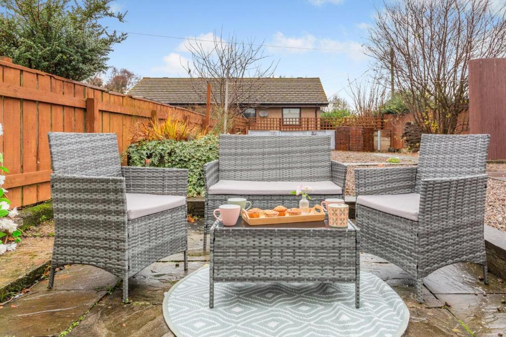a patio with three chairs and a table with a bowl of oranges at 2 Bed in Lowick oc-c34008 in Lowick