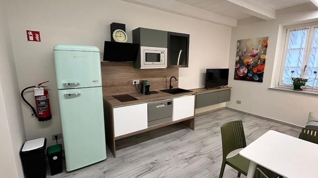 a kitchen with a refrigerator and a table in a room at Baratà Apartments 2 in Savigliano