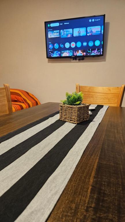 una camera con tavolo e TV a parete di Edificio-Pellegrini PA a Bragado